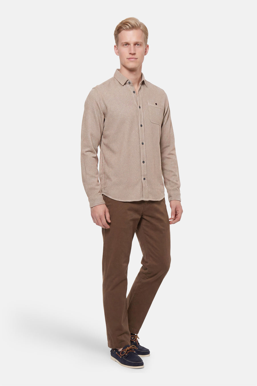 Beige long-sleeve shirt with textured weave and chest pocket, worn by model in full-length front view with brown pants and navy boat shoes