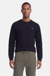 Navy blue ribbed crewneck sweatshirt by Petrol Ind, featuring small chest patch, worn with olive green drawstring pants, front view.