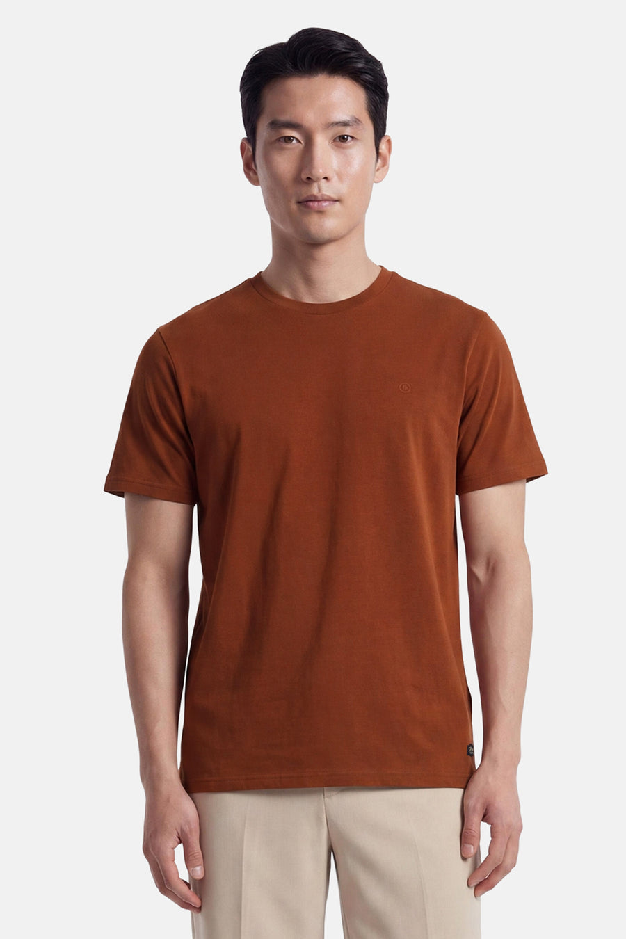 Orange short-sleeve t-shirt with round neckline and small chest logo, worn by model in front view