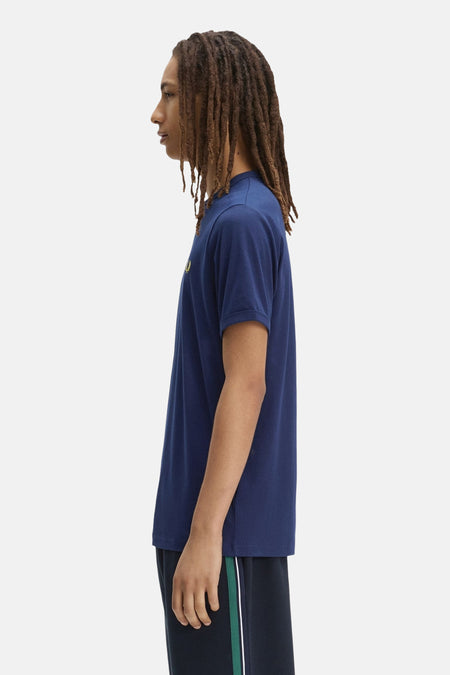 Blauwe T-shirt met korte mouwen van FRED PERRY, met geborduurd geel lauriertaklogo, van opzij gedragen.