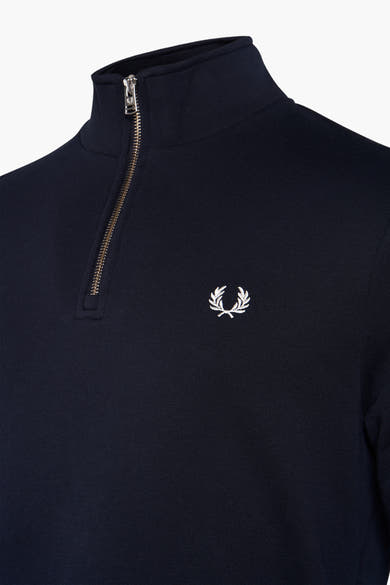 Blauwe sweatstof met opstaande kraag van FRED PERRY met gouden ritssluiting en geborduurd logo.