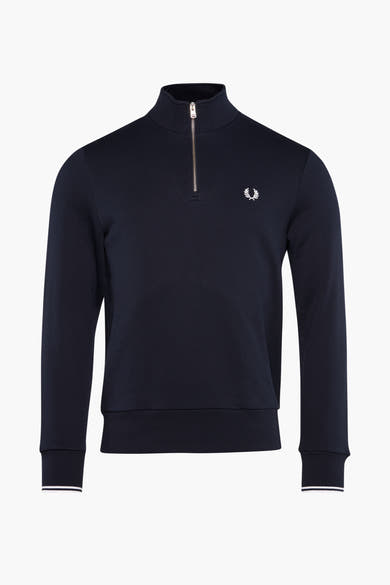 Blauwe sweater met opstaande kraag van Fred Perry, met zilveren ritssluiting en geborduurd logo op de borst.