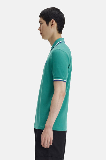 Polo à manches courtes vert de FRED PERRY, avec des finitions rayées au niveau du col et des manches.