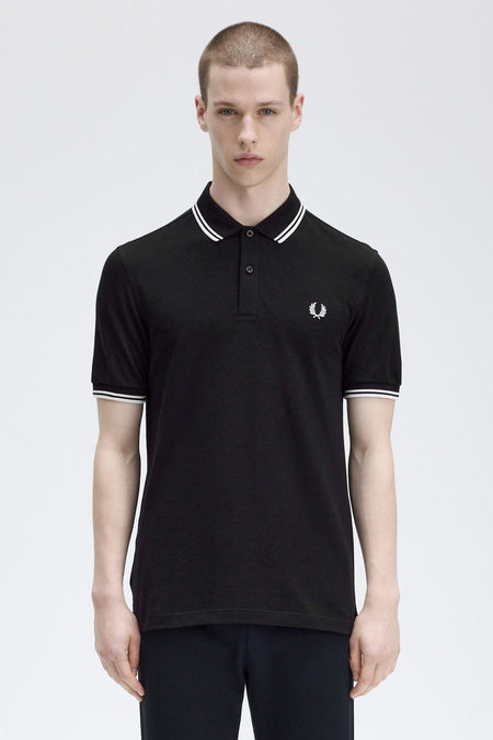 Zwart poloshirt met korte mouwen van Fred Perry, met witte gestreepte kraag en mouwen, geborduurd logo.