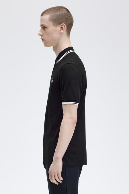 Zwart poloshirt met korte mouwen van FRED PERRY, met witte strepen op de kraag en mouwen.