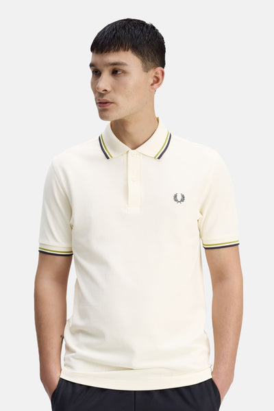 Polo écru en coton piqué de Fred Perry, avec rayures contrastées au col et aux manches, logo brodé.
