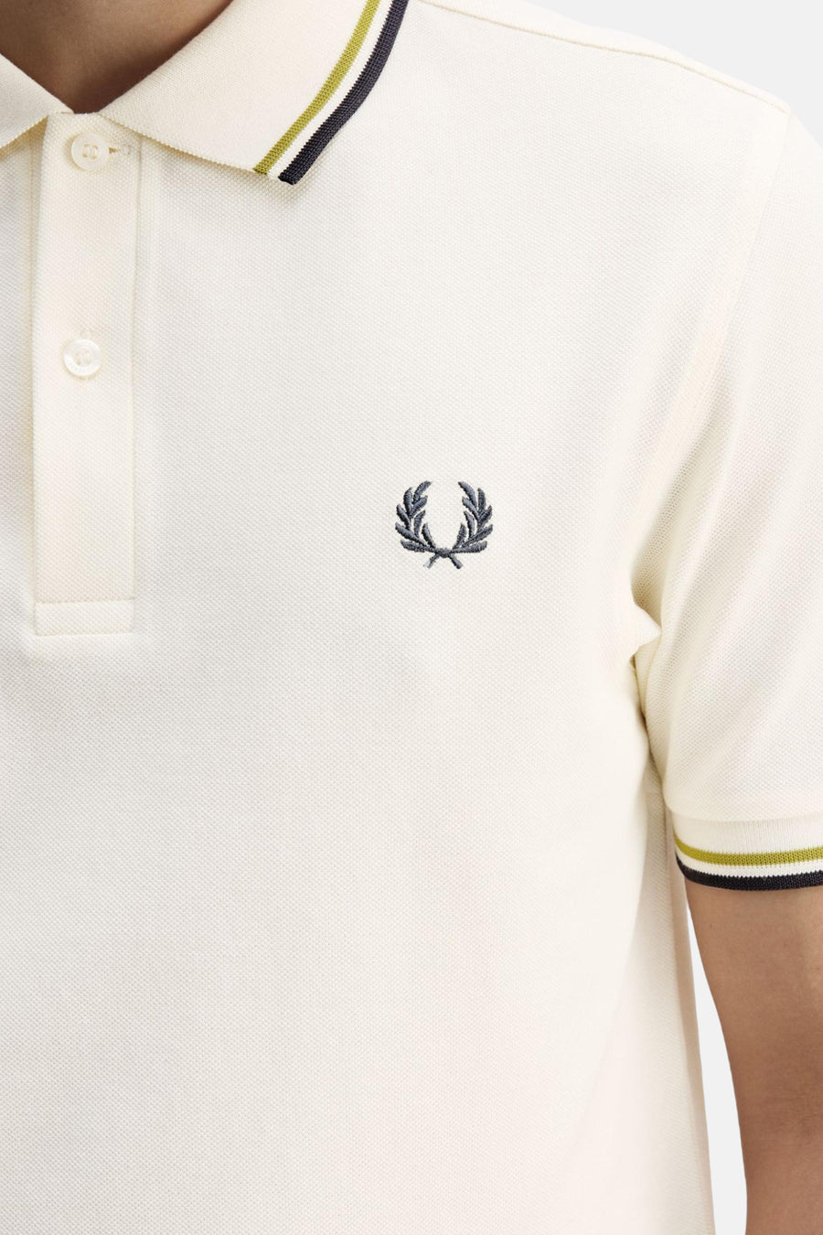 Ecru polo van Fred Perry, met dubbele streep op de kraag en geborduurd logo.