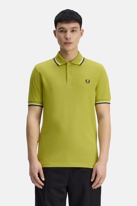 Groen poloshirt van FRED PERRY, klassieke pasvorm met contrasterende strepen op de kraag en mouwen, zijaanzicht.