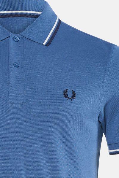 Blauwe polo van FRED PERRY met gestreepte kraag in wit en geborduurd logo op de borst.