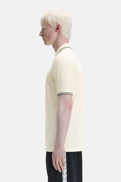 Polo à manches courtes écru de FRED PERRY, avec rayures contrastantes au col et aux manches.