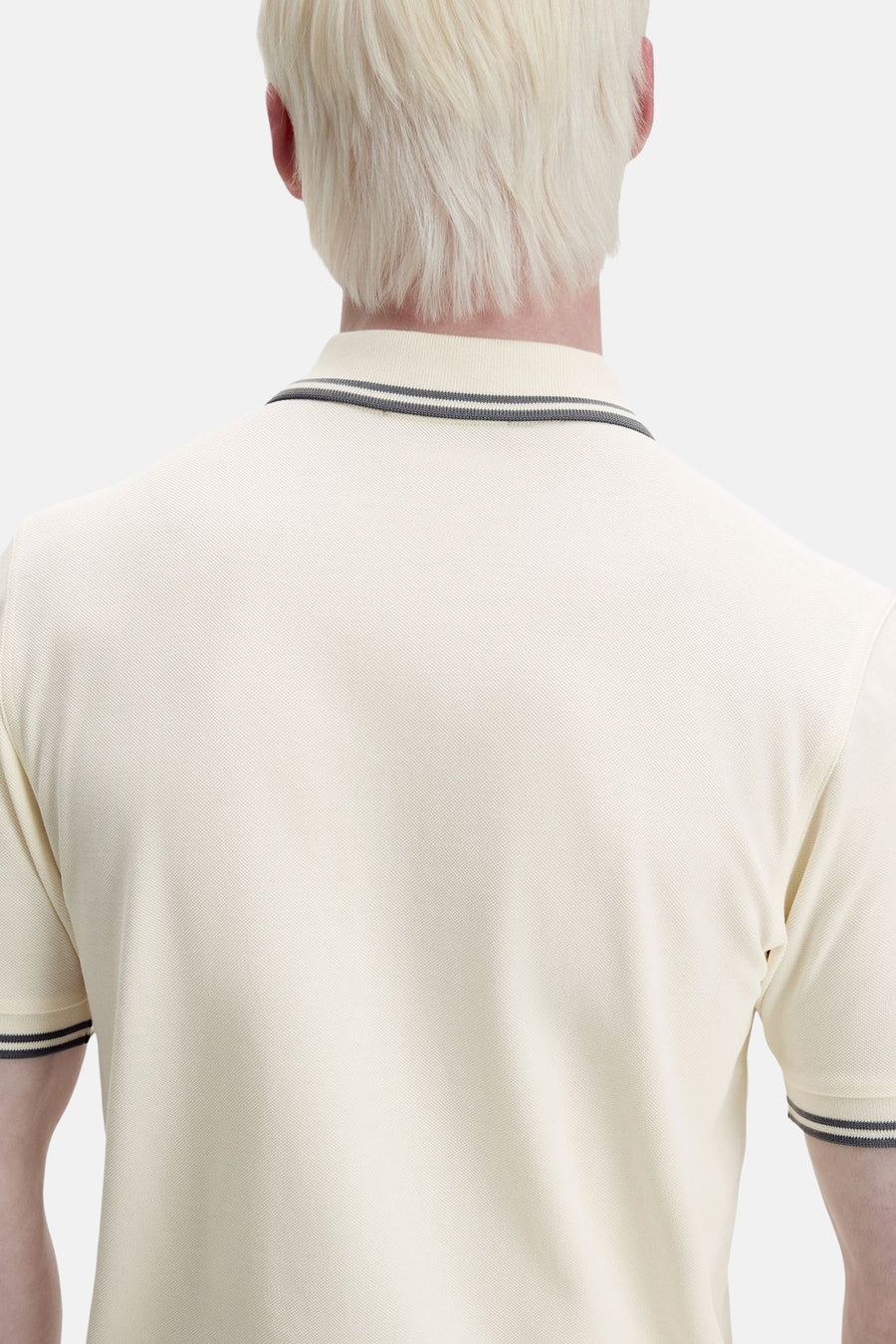 Polo à manches courtes écru de Fred Perry, détail rayé au col et aux manches, vue de dos.
