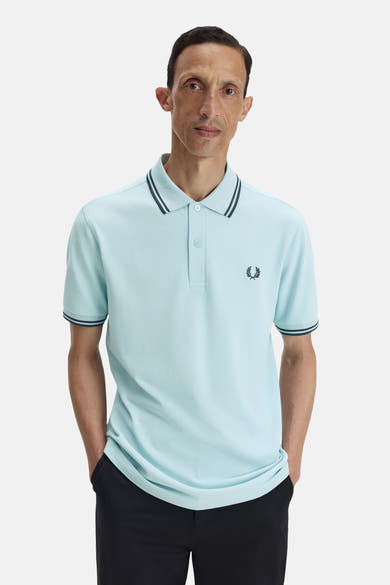 Polo bleu à manches courtes de Fred Perry, orné du logo distinctif et de détails rayés.