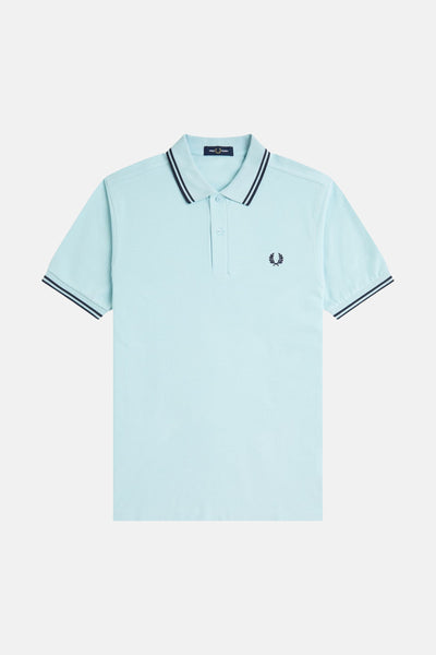 Blauwe polo met korte mouwen van Fred Perry, met marineblauwe strepen op de kraag en mouwen, en geborduurd logo.