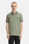 Polo à manches courtes vert de FRED PERRY, avec bordures rayées au col et aux manches, logo brodé.
