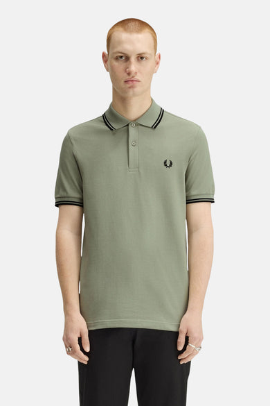 Polo à manches courtes vert de FRED PERRY, avec bordures rayées au col et aux manches, logo brodé.
