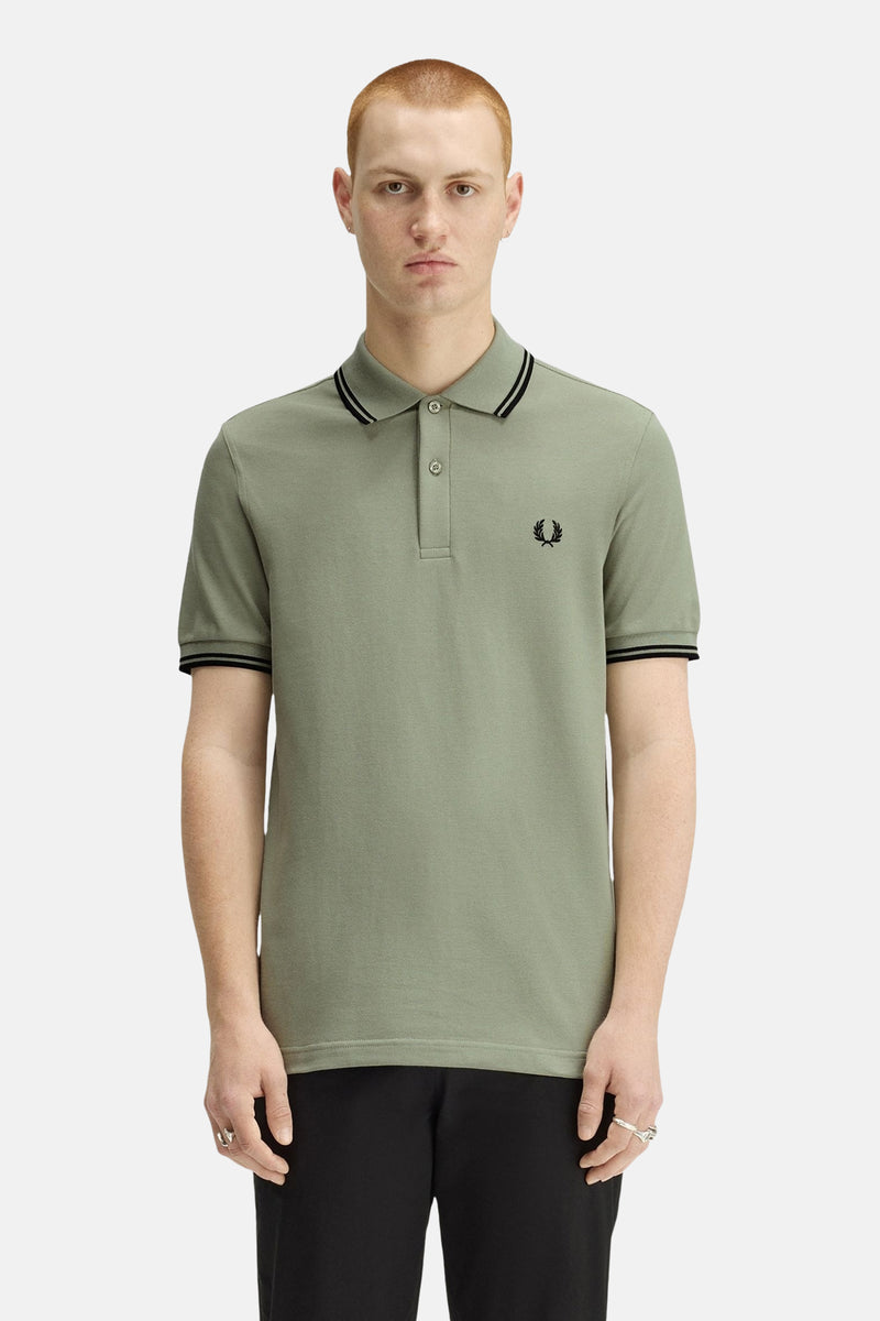 Polo à manches courtes vert de FRED PERRY, avec bordures rayées au col et aux manches, logo brodé.
