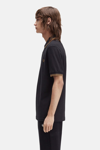 Polo noir à manches courtes de Fred Perry, avec col et ourlets contrastés couleur caramel.