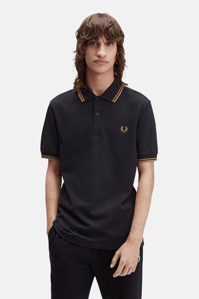 Polo noir à manches courtes de Fred Perry, avec finitions rayées contrastantes au col et aux manches.