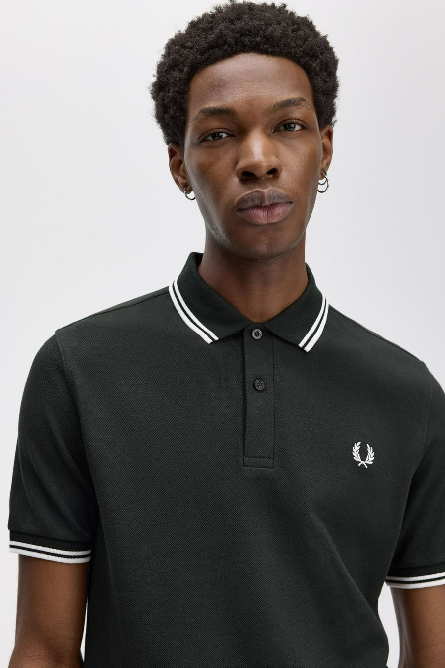 Polo vert par FRED PERRY avec rayures blanches au col et aux manches courtes, logo sur la poitrine.
