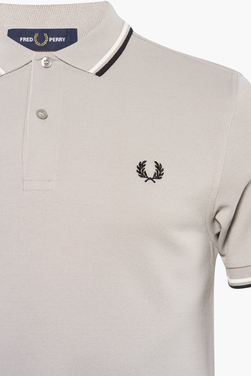 Grey pique polo shirt by Fred Perry with black embroidered laurel wreath logo and striped collar trim, front close-up view
