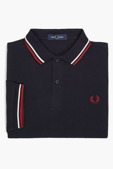 Polo bleu à manches courtes de Fred Perry, avec rayures contrastées au col et aux manches, logo brodé.
