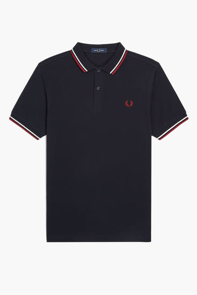 Polo bleu à manches courtes de FRED PERRY, avec col et ourlets rayés rouge et blanc, logo brodé.
