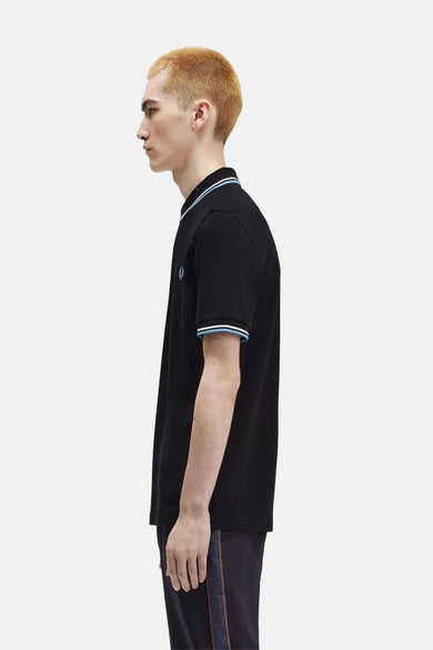 Polo à manches courtes noir de Fred Perry, avec rayures contrastées au col et aux manches.