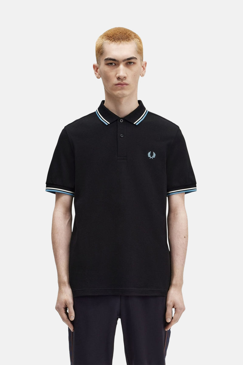 Polo noir à manches courtes de Fred Perry, avec rayures contrastantes sur le col et les manches.