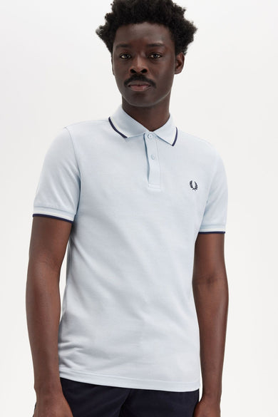Polo bleu à manches courtes de Fred Perry, avec col et bordures de manches contrastées.