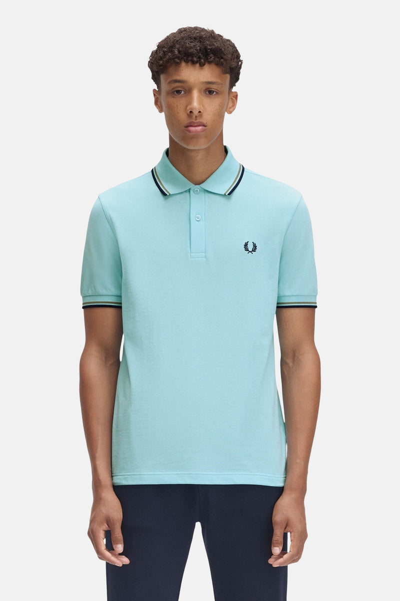 Polo turquoise à manches courtes de Fred Perry, avec col et manches rayés.
