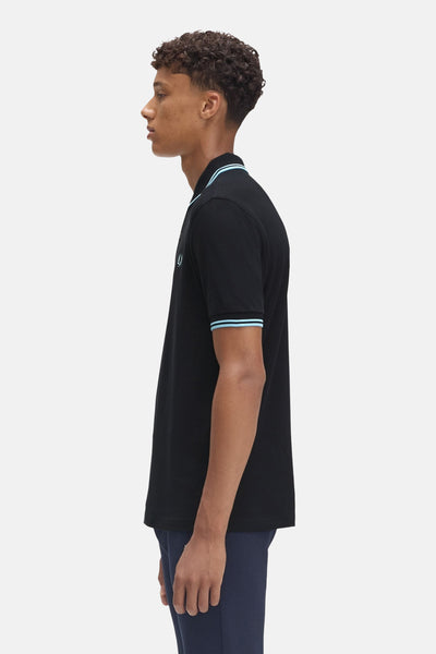 Polo à manches courtes bleu foncé de FRED PERRY, avec rayures contrastées au col et aux manches.