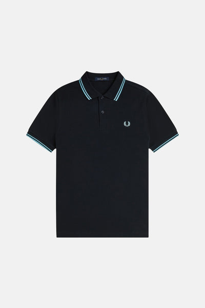 Polo bleu foncé à manches courtes de Fred Perry, avec rayures bleu clair au col et aux manches.