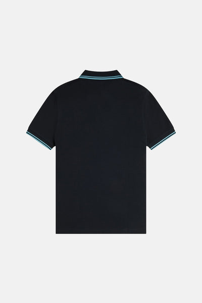 Polo bleu foncé à manches courtes de FRED PERRY, avec liserés bleus sur le col et les manches.