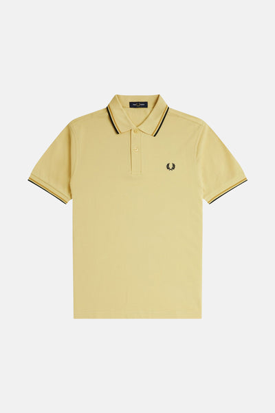 Polo à manches courtes jaune de FRED PERRY, rayures noires et dorées au col et aux manches, logo brodé.