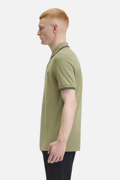 Polo à manches courtes olive de FRED PERRY, avec col et bordures des manches rayés, vue de côté.