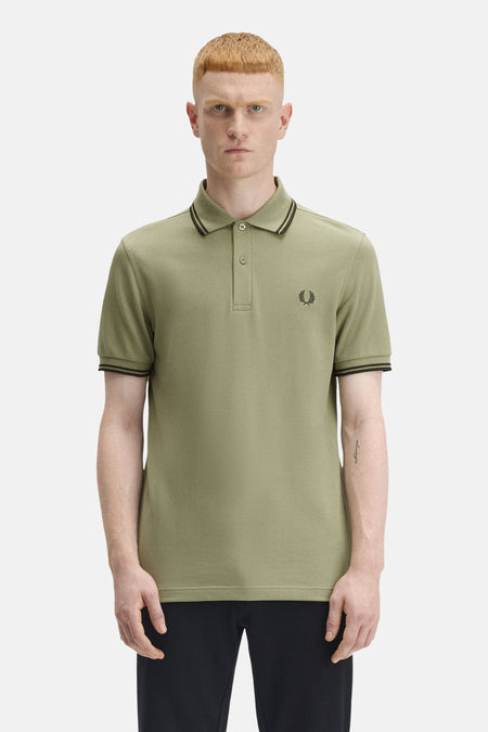 Olijfgroen poloshirt met korte mouwen van Fred Perry, met kraag en mouwen met zwarte strepen en geborduurd logo.