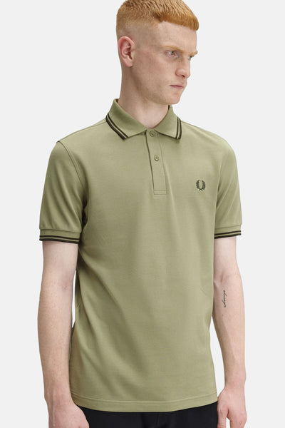 Polo olive à manches courtes de Fred Perry, avec col et manches à rayures noires.