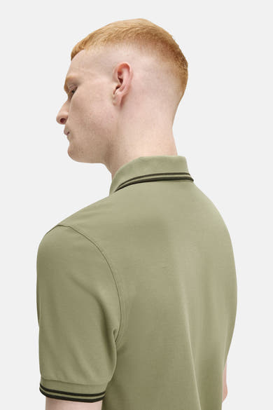 Polo à manches courtes olive de FRED PERRY, avec col et bordures de manches rayés.