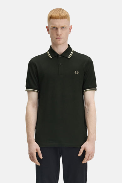 Polo à manches courtes vert de Fred Perry, avec rayures contrastées au col et aux manches, et logo brodé.
