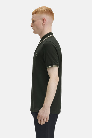Polo à manches courtes vert de FRED PERRY, avec bordures contrastées au col et aux manches, en vue de côté.
