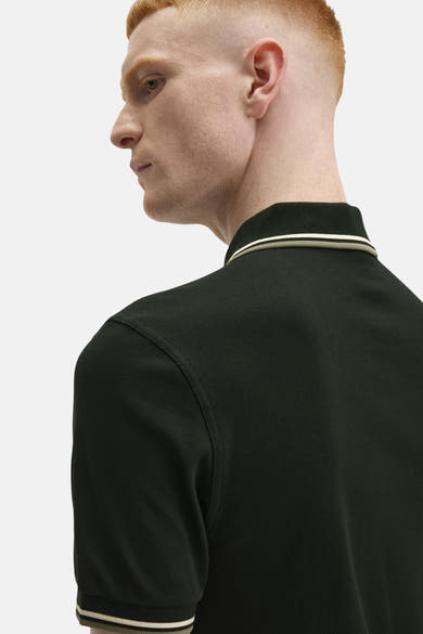 Polo à manches courtes vert de FRED PERRY avec bordure rayée au col et aux manches.