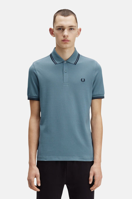 Blauwe Fred Perry polo met korte mouwen, met gestreepte kraag en boorden.