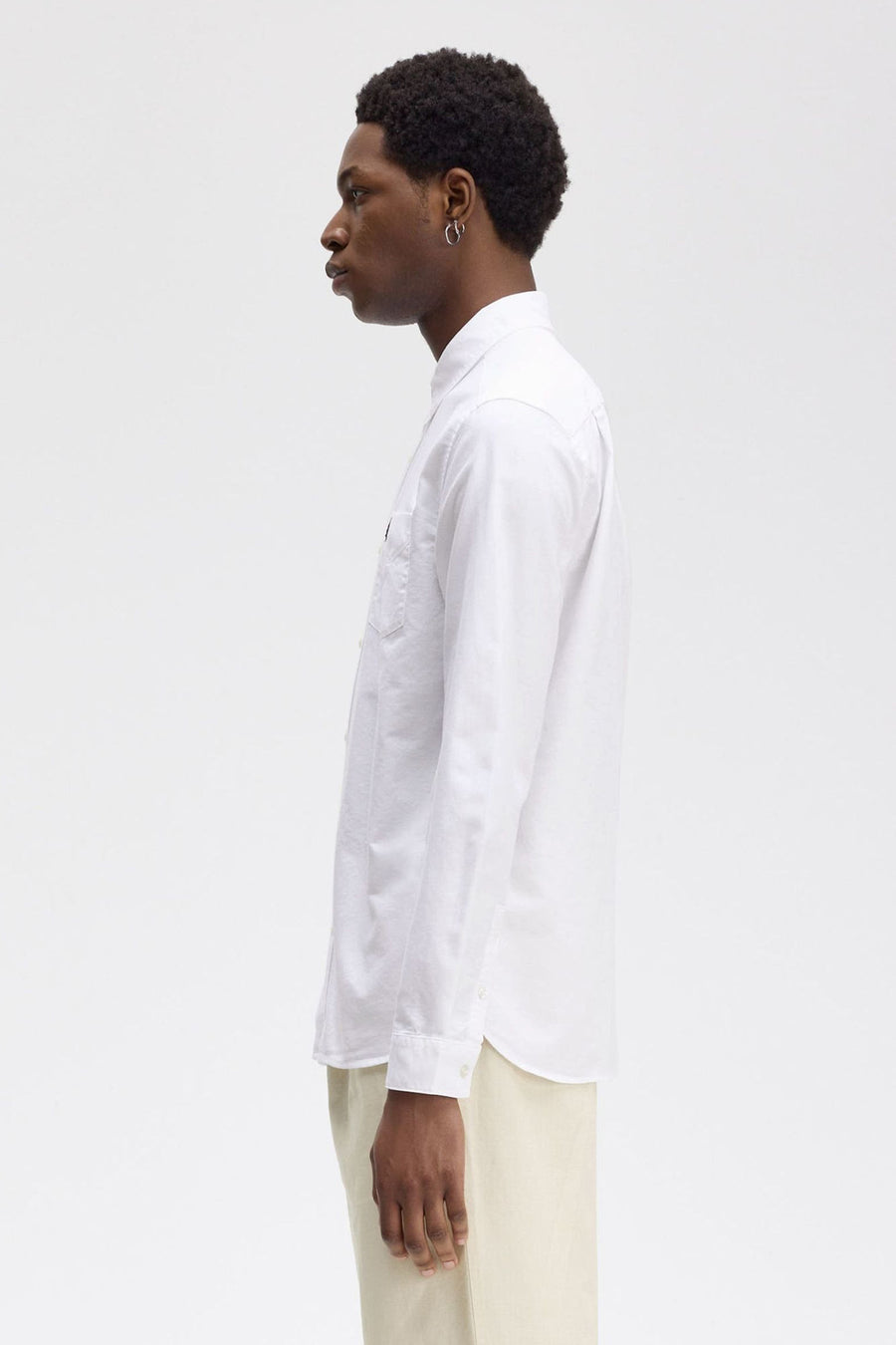 Wit overhemd met lange mouwen van FRED PERRY, zijaanzicht, met borstzak en een beige broek.