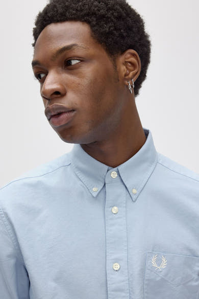 Blauwe blouse met lange mouwen van FRED PERRY, met borstzak versierd met een toon-op-toon borduursel.