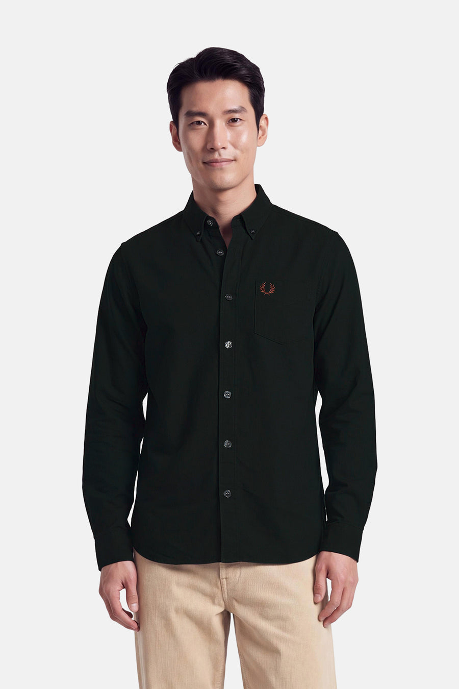 Chemise à manches longues FRED PERRY vert foncé, portée par un mannequin, avec col boutonné, poche poitrine et logo brodé.