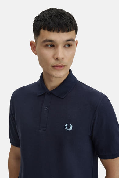 Polo bleu marine de Fred Perry, avec logo brodé ton sur ton et patte de boutonnage discrète.
