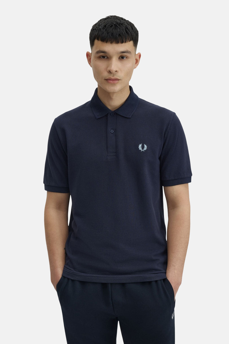 Polo bleu marine de Fred Perry, avec logo laurier brodé sur la poitrine et deux boutons au col.