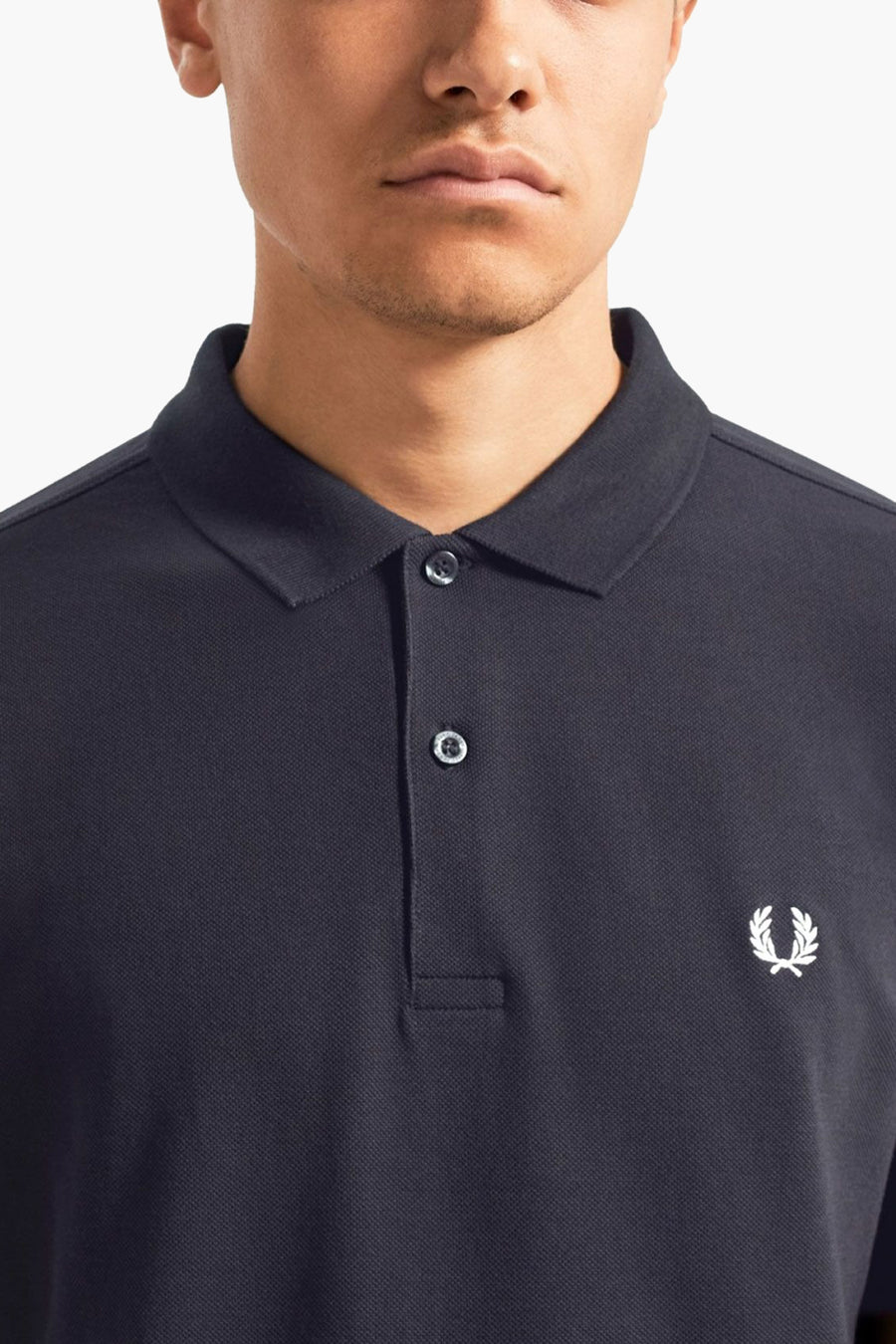Polo bleu de Fred Perry avec logo brodé sur la poitrine.
