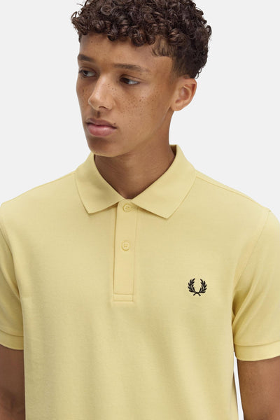 Gele Fred Perry polo met korte mouwen en geborduurd logo op de borst.