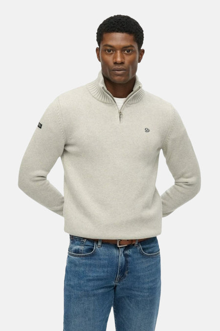 Pull à col roulé gris by SUPERDRY, avec fermeture éclair et petit logo sur la poitrine, porté avec un jean et une ceinture marron
